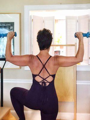 Student using weights and the Pilates chair in a private lesson.