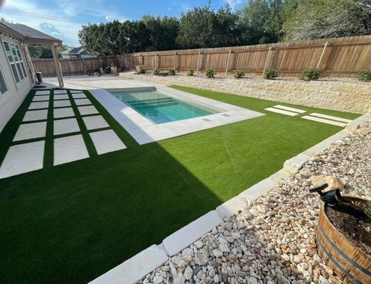 Backyard artificial grass and pavers around pool