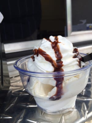 Mini vanilla ice cream scoop with whipped cream and chocolate syrup