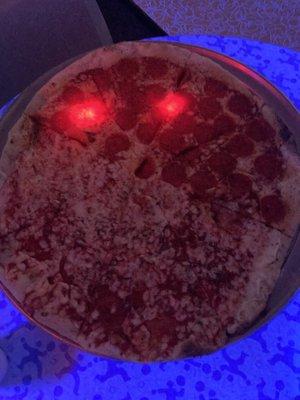 Half Pepperoni Pizza, half cheese pizza under the neon lights