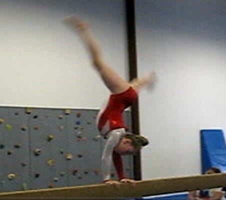 Balance beam with rock-climbing wall in background