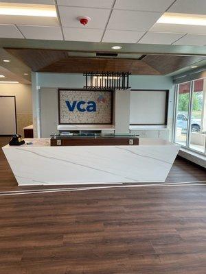 Custom reception desk with a custom wood accent on the ceiling