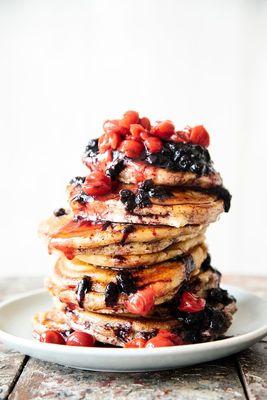 Pancakes stacked high made with our Wheat & Malt Pancake Mix and Fruit Perfect Cherries and Blueberries.