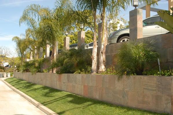 This is a set of two retaining walls with slate tile facing and new sod and landscaping.