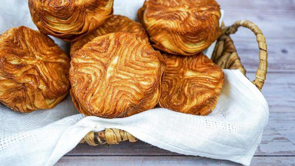 A kouign amann is a buttery, sweet, and sticky pastry; it has a flaky and layered texture.