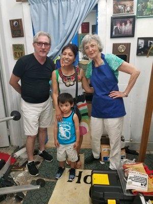 one of our partner family homeowners and her son visiting with two of our full-time volunteers at our office