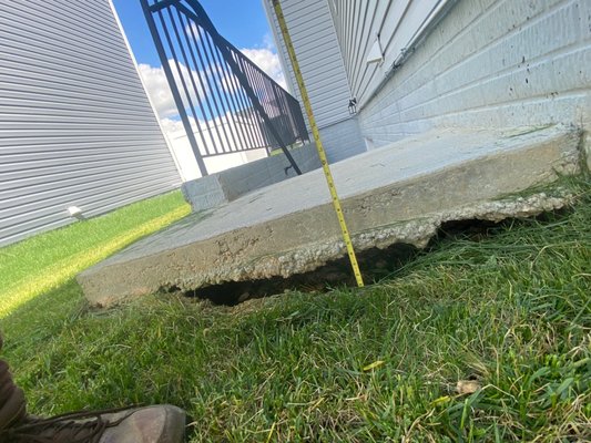 Another view of the areaway sinkhole.  A full 9" below the top of the landing to the top of the grass. But the sinkhole is another 2" below.