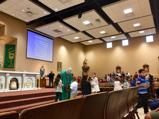 Priest gathering children for 10:30am mass