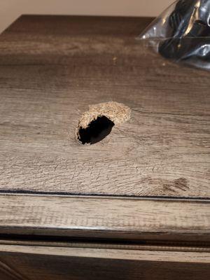 A 4 inch hole in the top of a chest of drawers.