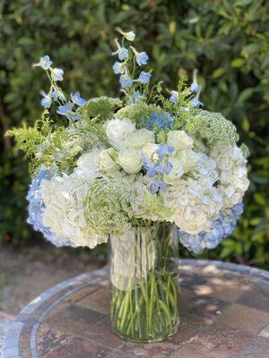 Flower arrangement with fresh white and blue flowers and greenery