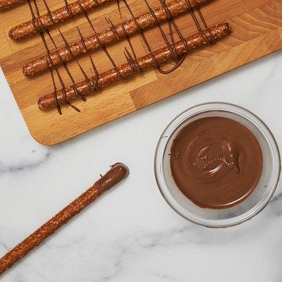 Milk Chocolate Wafers Melted In A Bowl With Chocolate Covered Pretzels