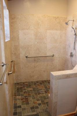 Originally built with a now outdated tub, Nash Construction has reconfigured this master bathroom into a large, travertine, walk-in shower.