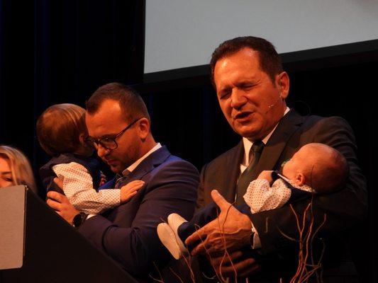 Agape's Senior Paster, Crinisor Stefan, dedicates a baby next to his family.