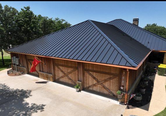 Slick black metal roof with cooper gutters