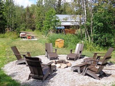 Fire pit and outdoor dining area with gas grill and firewood provided.