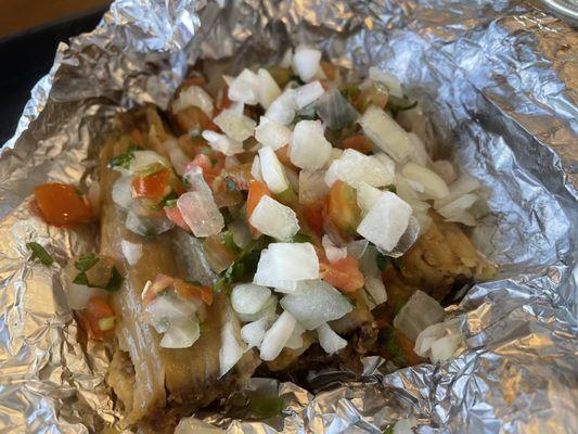 Tiny brisket tamales covered in condiment bar pico