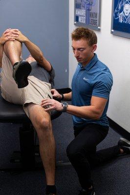 Assessing hip and quad tension with the Thomas Test.