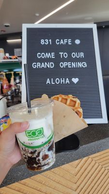 Grand opening sign of 831cafe with an Iced Cloud Coffee Drink ($5.79) and an 831 Original Waffle ($3.50).