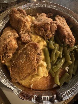 Cornbread bowl with fried chicken and two sides.