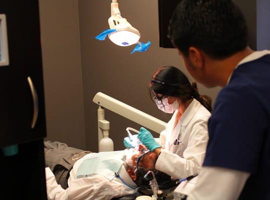 Dr. Imaney working with an assistant on a patient