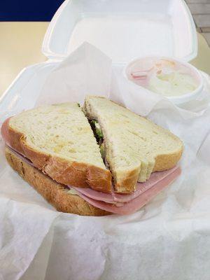 Ham sandwich with toasted bread and a tiny fruit cup