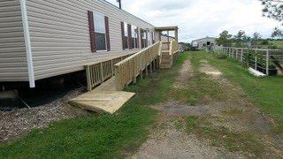 Pressure treated deck with handy cap ramp and steps. With small covered setting area.