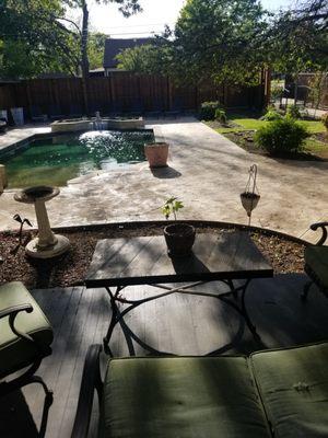 A partial view of the backyard from the porch. It is a nice sitting area.