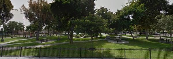 View of the front lawn with tables & BBQ stands looking from Gage Ave.