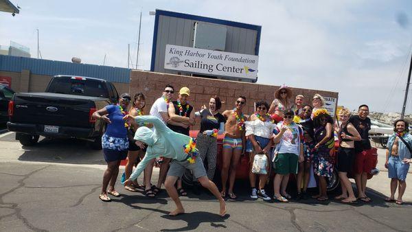 Group shot of Pride Paddleout with Jeremy from Olympus Standup Paddleboards doing a cartwheel..