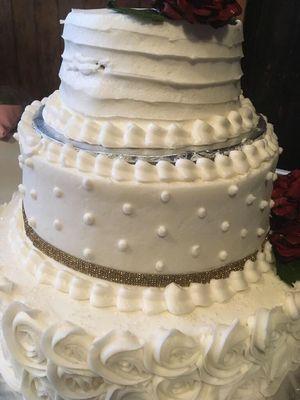 Why is there broken icing and a aluminum foil on my wedding cake? The cake is lopsided