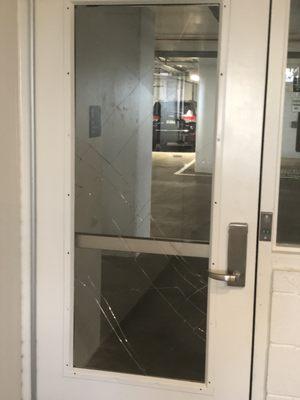 Vandalized door in parking garage.