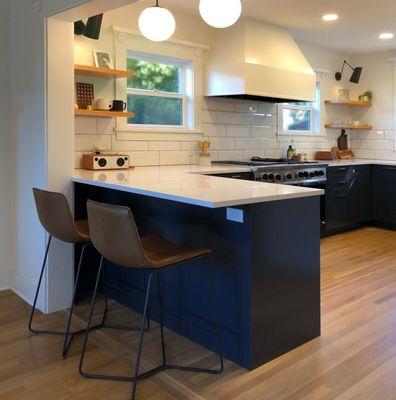 We opened up the kitchen, which had previously included a separate breakfast nook, added large windows to bring in natural light and enlarge