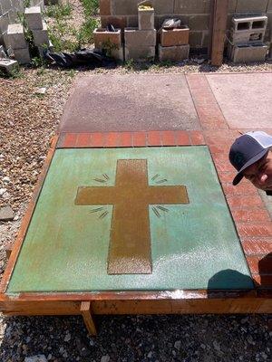 Cross design cut into concrete saw and finished with acid stain. Work performed by Graham and Matt.