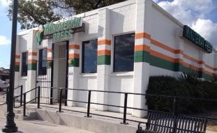 Front entrance with new sidewalk and recently repainted building, parking lot on the right hand side of building.