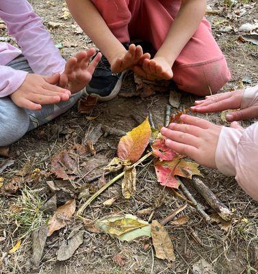 Embracing the warmth and simplicity of play, these hands find comfort in an imaginary fire made of twigs and autumn leaves.