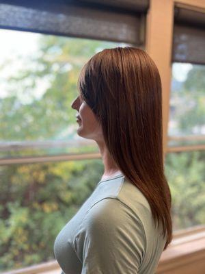 Curtain Bangs with a Flowing Layered Haircut and Golden Light Brown Hair Color.