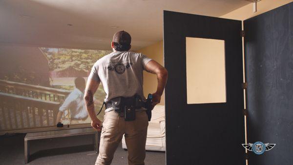 Prior to firearm training at the range, students practice emergency intruder scenarios using a simulator.