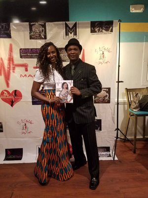 Mia Speight (left) with photographer John Hudson (right) holding cover of Vital Magazine where she is featured as the cover.