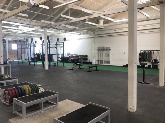 View of the long turf- 30 yards- and weight lifting rig for the Crossfit area. Medicine balls, dumbbells and kettlebells