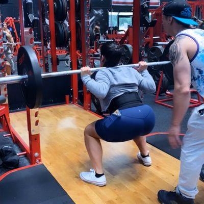 Perfecting the squat game! ‍ Coach's watchful eye, client's dedication - capturing the moment of form refinement.