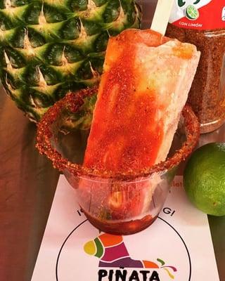 Spicy mango mexican popscicle dipped in chamoy and tajin.