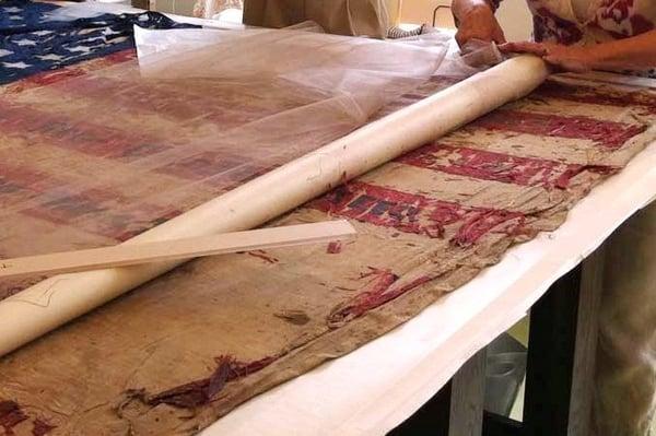 Delicate handling of a Civil War flag in the Textiles lab