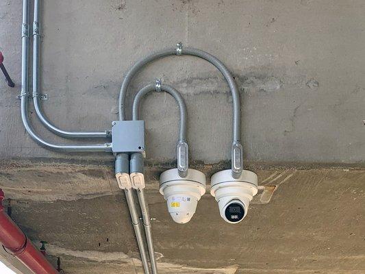 Security cameras with conduit raceways to protect cables.