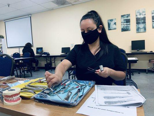 Our student, Christine, identifiying the different tools in our Dental Assistant Program.