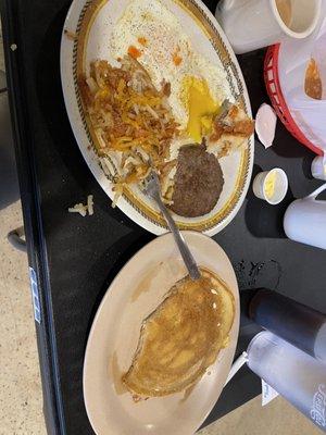 Two egg breakfast with sausage hash browns and a biscuit, one pancake