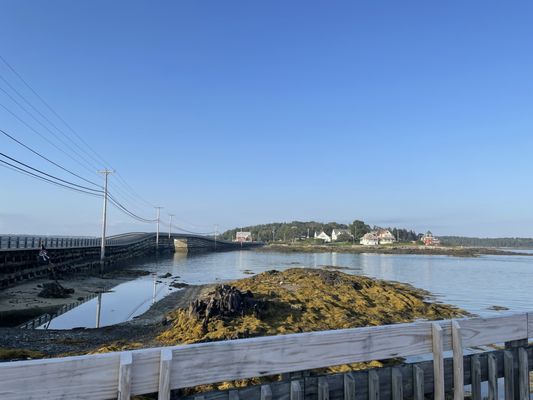 View of the Cribstone bridge connecting Baileys and Orr's Island from the Sundrenched out door seating on a dock.