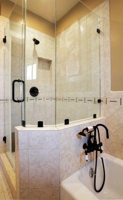 Porcelain shower area with a glass ribbon, custom wall niche, nickel oil brush faucets and frame-less glass door