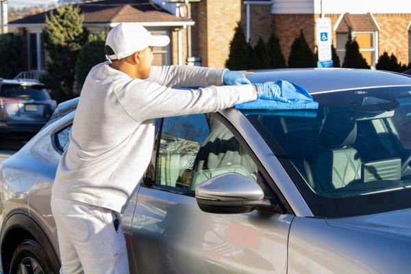 Drying the car after hand washing and spray wax application