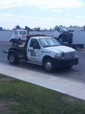 The tow truck was clean and the driver was dressed nice.