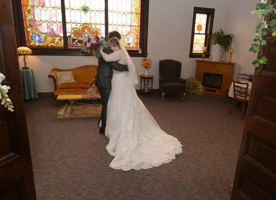 The couple embraces in the bridal suite after the ceremony.  By Holmes Photography Studio